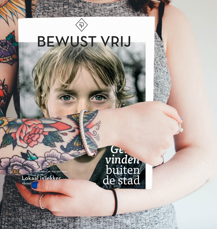 Persoon met tatoeages op arm houdt het bewust vrij magazine vast